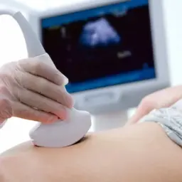 Lekarz wykonuje USG brzucha, aby sprawdzić, czy wszystko jest w porządku. Na ekranie widać obraz z sondy, który pomoże w diagnozie.