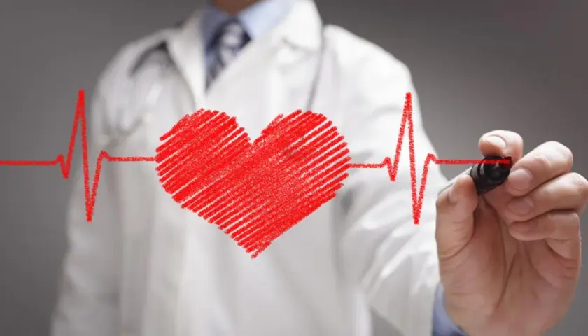 Lekarz w białym kitlu rysuje serce i linię EKG. Dbałość o zdrowie, to nie tylko nebilenin, ale przede wszystkim troska o serce.