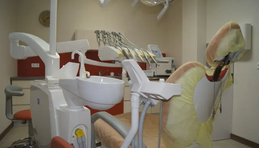 Nowoczesny gabinet stomatologiczny z fotelem dentystycznym i narzędziami.